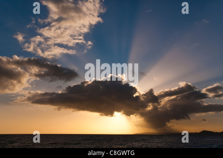 Dramatic clouds & setting sun on Devon beach Stock Photo