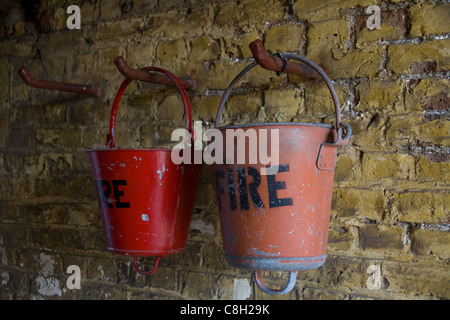 Old fire buckets hang from pegs on the walls at Landguard Fort, Felixstowe, Suffolk Stock Photo