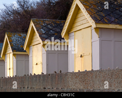Three traditional wooden beach huts on the sea front at Folkestone in Kent England UK Stock Photo