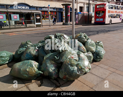 Sacks of rubbish piled up on the street in plastic bags waiting for to be collected Stock Photo