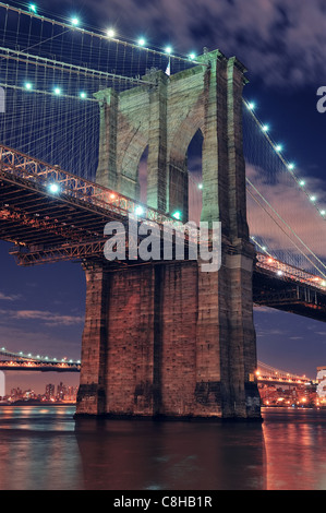 Brooklyn Bridge closeup over East River at night in New York City