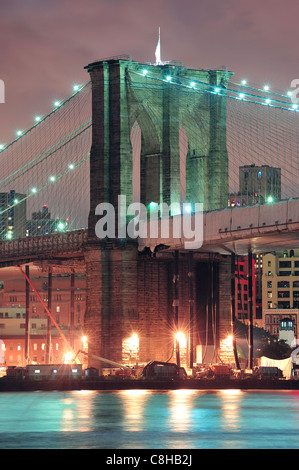 Brooklyn Bridge closeup over East River at night in New York City