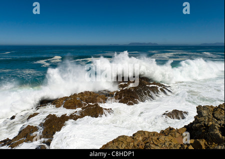 Waves crushing on the boulders along Route 44 Table Mountain in the background South Africa Stock Photo