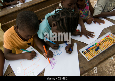 Orphans drawing in a camp for survivors of a 7.0 magnitude earthquake which struck Haiti on 12 January 2010 in  the outskirts of Port-au-Prince Stock Photo