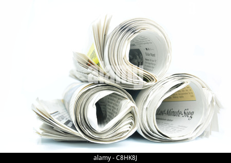 Three rolled up newspapers on white background Stock Photo