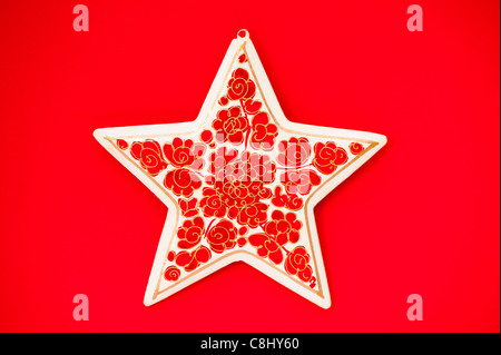 Papier-mâché star against a red background Stock Photo