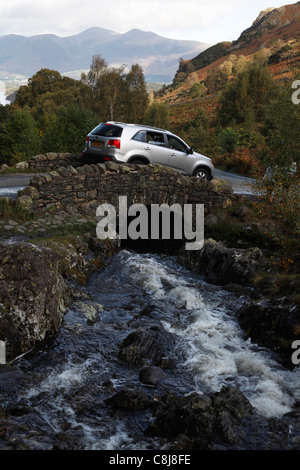 Car driving over [Ashness Bridge], Borrowdale, [Lake District National Park], Cumbria, England, UK Stock Photo