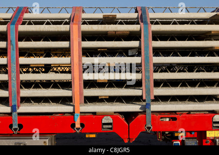 A stack of prefabricated concrete slabs with integrated lattice girders is delivered to a construction site. Stock Photo