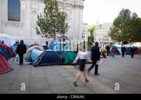 Passers-by walk past the anti-capitalist protesters' camp outside St Paul's Cathedral, London, October, 2011. Stock Photo
