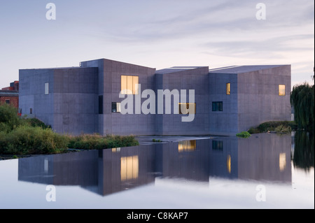 The Hepworth Gallery art museum on waterfront banks of River Calder, reflected in water (lights on at dusk) - Wakefield, West Yorkshire, England, UK. Stock Photo