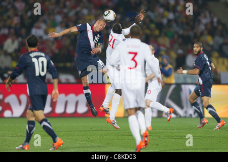 Jay DeMerit of the United States (L) and Emile Heskey of England (R) battle for a header during a FIFA World Cup Group C match. Stock Photo
