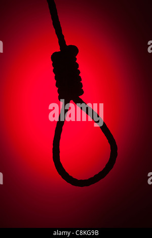Silhouetted Hangman's Noose Over Red Spot Lit Background. Stock Photo