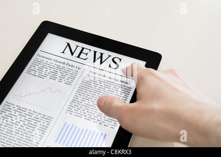 Man hands are touching tablet pc device with daily news. Stock Photo
