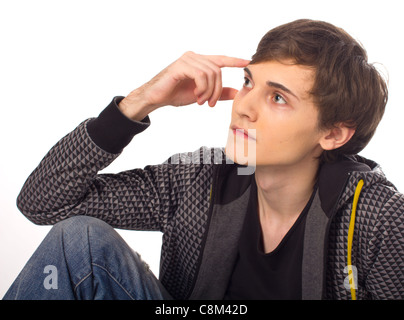 Handsome young man sitting and thinking on white background Stock Photo