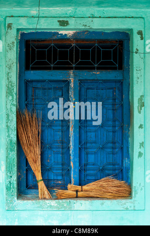 Old Indian village house / window detail with sweeping brushes on the ledge. Andhra Pradesh. India Stock Photo