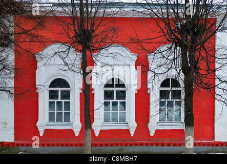 Red brick wall with three windows Stock Photo