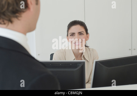 Hispanic businessman talking to receptionist Stock Photo