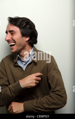 Portrait of happy young man laughing on white background Stock Photo