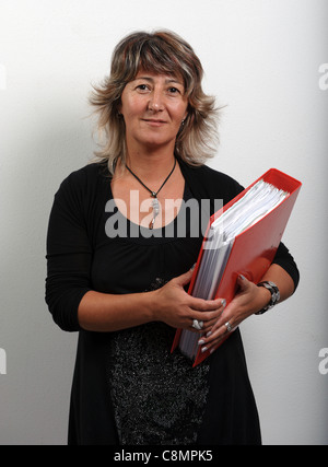 Female office worker holding file folders on ring binder Stock Photo