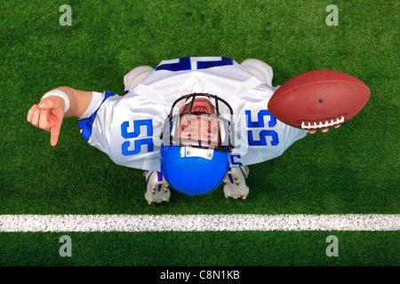 Overhead photo of an American football player making a touchdown celebration looking up in the air with his finger raised. Stock Photo