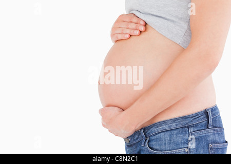 Side view of a young pregnant woman caressing her belly while standing Stock Photo