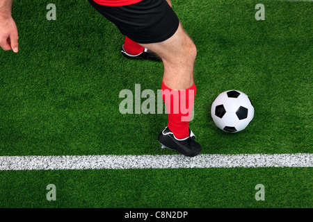 Overhead photo of a football or soccer player dribbling with the ball on the sideline
