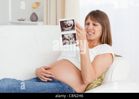 Pregnant woman looking at her baby's ultrasound scan Stock Photo