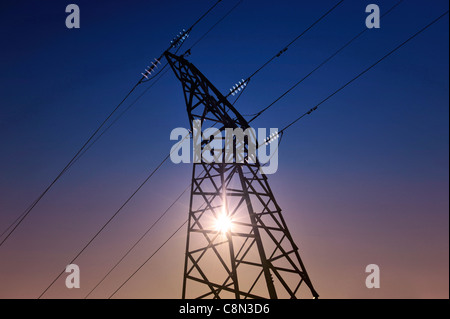 Sun setting behind a electrical transmission tower Stock Photo