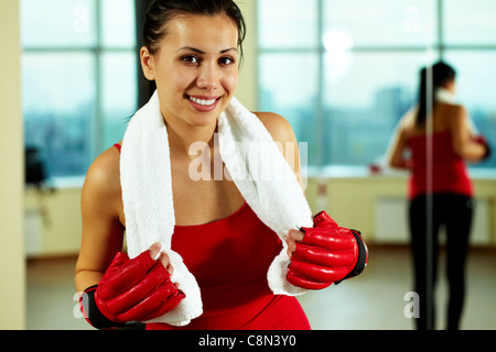 Portrait of young woman in red gloves and with towel looking at camera Stock Photo