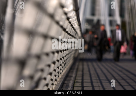 a low view along The Golden Jubilee Bridge, London, with out of focus people in the distance Stock Photo