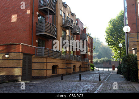 Empty cobbled road with bollards running between 2 blocks of modern flats Stock Photo