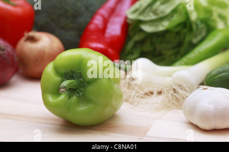 Close-up of a green pepper on a cutting board with many vegetables. Stock Photo