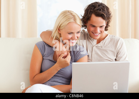 Smiling young couple using a laptop Stock Photo
