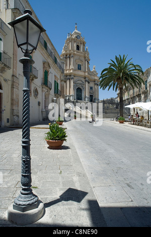 Italy, Sicily, Ragusa Ibla, Piazza del Duomo, Duomo di San Giorgio and street cafes, street light in the foreground Stock Photo