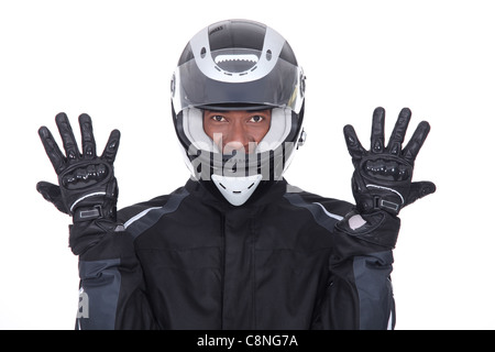 Motorcyclist wearing black jacket, gloves and helmet Stock Photo