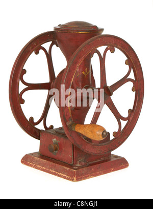 Coffee wheel grinder. Antique red iron wheel tabletop coffee grinder with tin drawer. Stock Photo