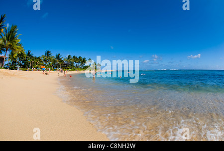 Sunny day at Poipu beach with white sand beach and palm trees, Kauai Stock Photo