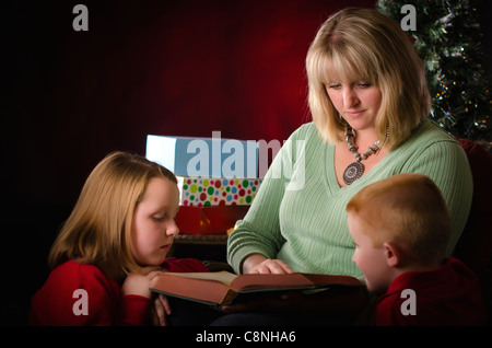 Mother reading a Christmas story to her children Stock Photo