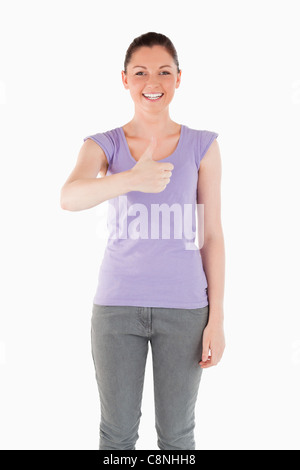 Beautiful woman posing with her thumb up while standing Stock Photo