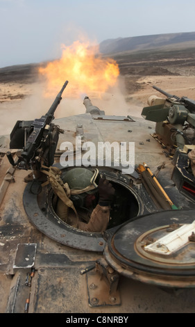 Lance Cpl. William Laffoon, tank crewman with Tank platoon Alpha Company, Battalion Landing Team 1st Battalion, 9th Marine Regiment, 24th Marine Expeditionary Unit, braces himself after firing a 120mm round from a M1A1 Abrams battle tank during a live-fire range in Djibouti, Africa March 30. Marine tank crewmen engaged several targets alongside the French 13th Foreign Legion Demi-Brigade as part a joint exercise. The 24th MEU is currently serves as the theatre reserve force for Central Command during its seven month deployment aboard Nassau Amphibious Ready Group vessels. Stock Photo