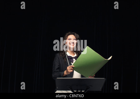 Smiling mixed race conductor holding folder Stock Photo