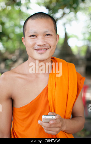 Cambodian monk text messaging on cell phone Stock Photo