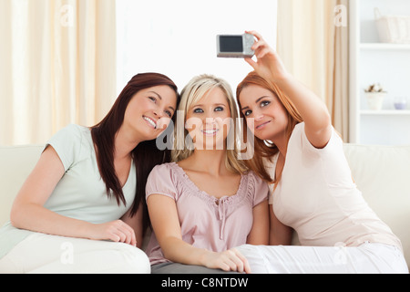 Cute women lounging on a sofa with a camera Stock Photo