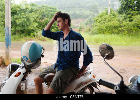 Caucasian man sitting on scooter Stock Photo