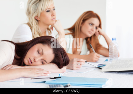University students one sleeping sitting at a table Stock Photo