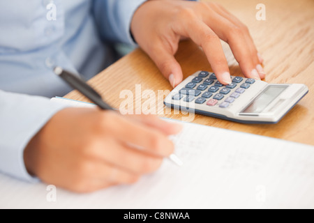Feminine hands using a pen and a calculator Stock Photo