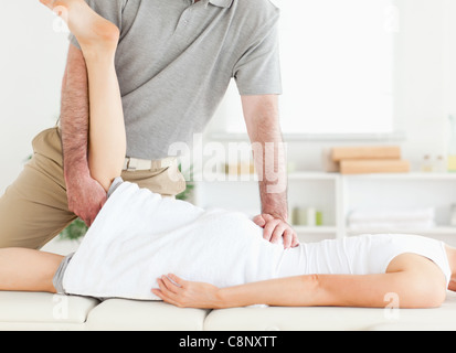 Chiropractor is stretching a woman's leg Stock Photo