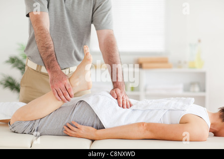 Chiropractor stretches woman's leg Stock Photo