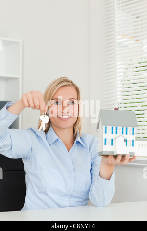 Businesswoman showing keys and model house Stock Photo - Alamy