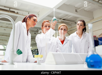Science students looking at a liquid in a flask Stock Photo